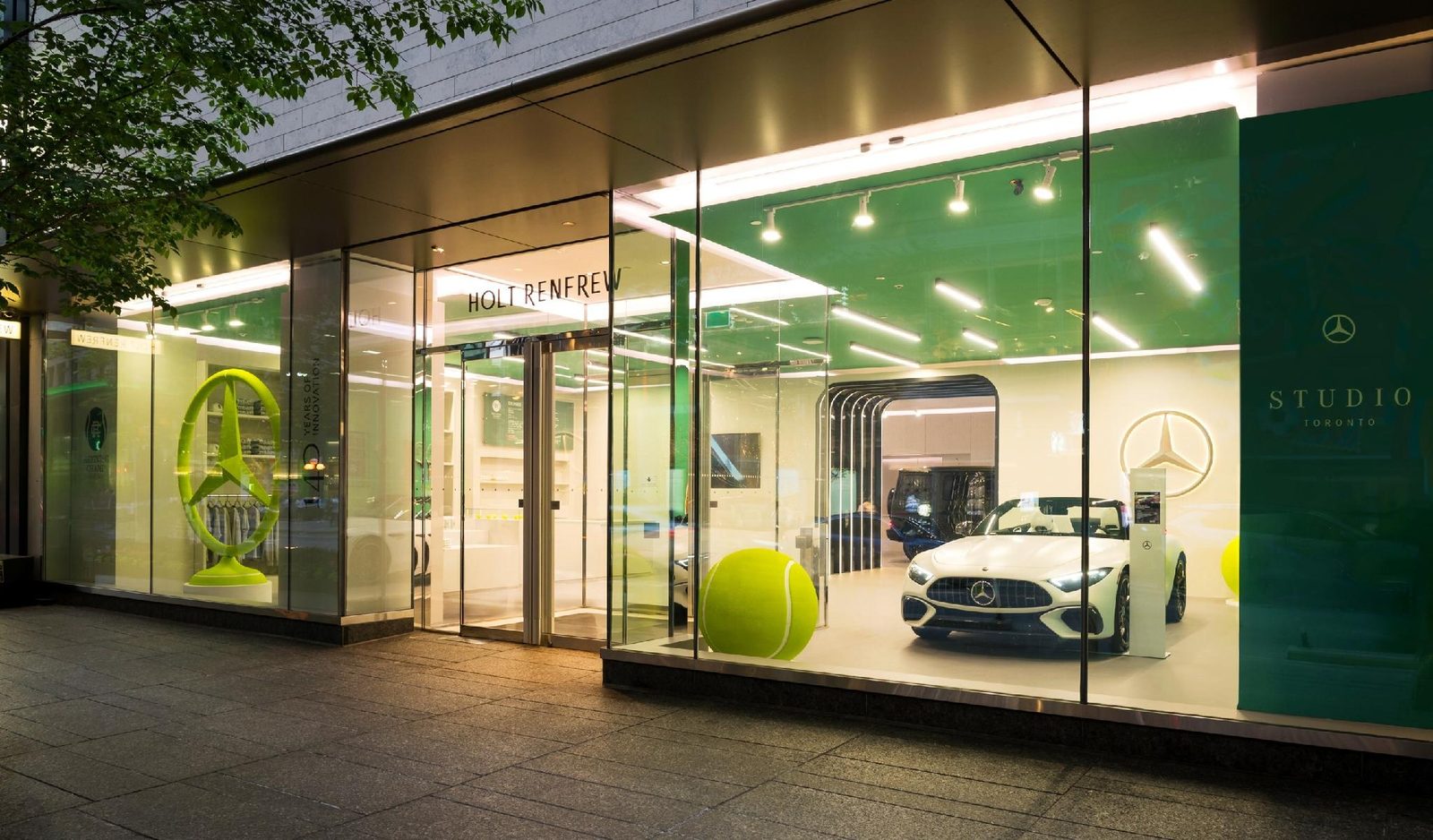 The Yorkville storefront at dusk: Studio Toronto in the Holt Renfrew glass, Mercedes-Benz Studio Toronto, Holt Renfrew Yorkville