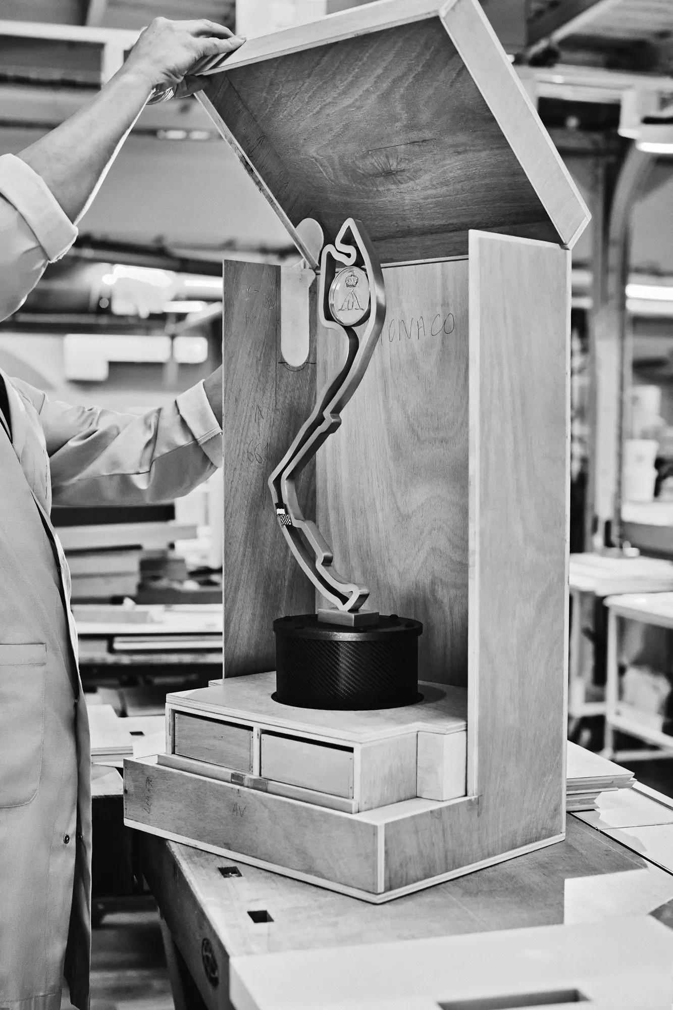 A Louis Vuitton artisan finishing a bespoke Trophy Trunk in the Asnieres atelier, the Monaco Grand Prix circuit sculpted inside